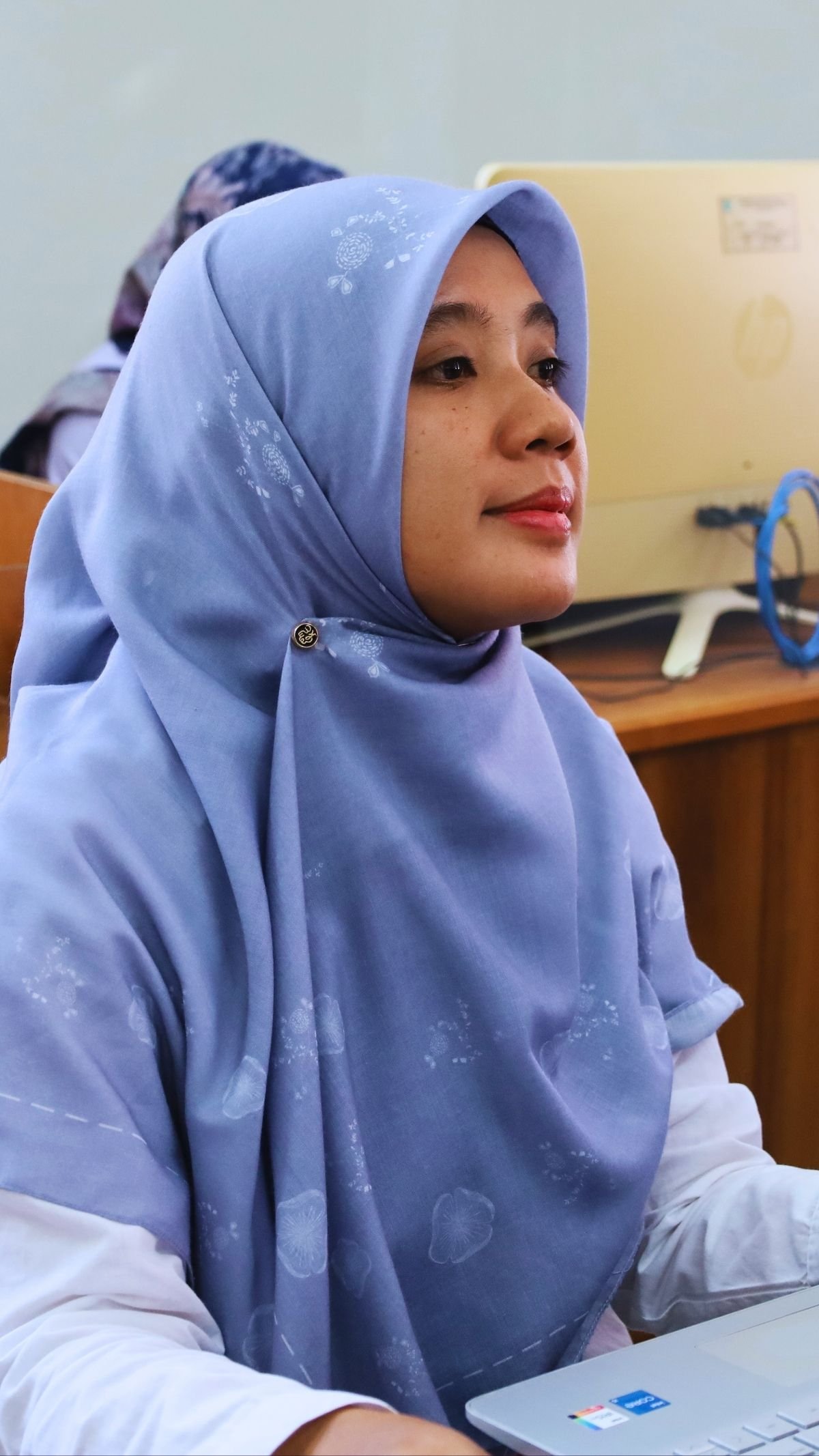Peserta perempuan mengikuti kegiatan di ruang laboratorium komputer.